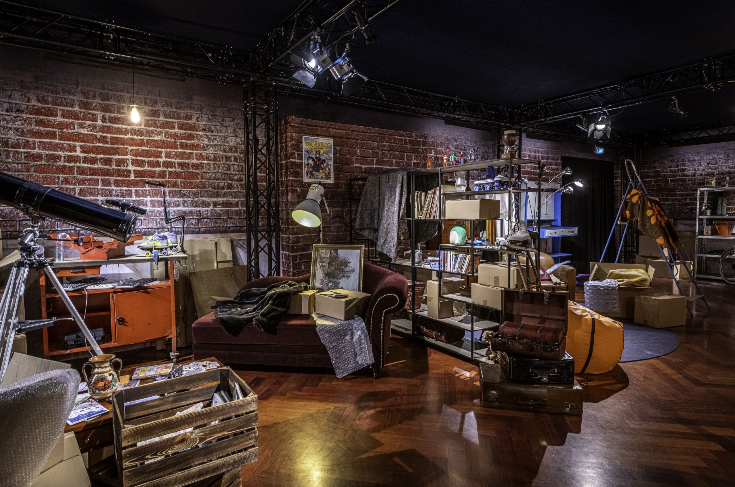 Immersive, room-scale scenography recreating a lived-in interior filled with everyday objects, books, furniture, and interactive elements, designed to place visitors in a relatable environment while addressing digital safety and awareness themes as part of the Action Innocence – Traveling educational pavilion.