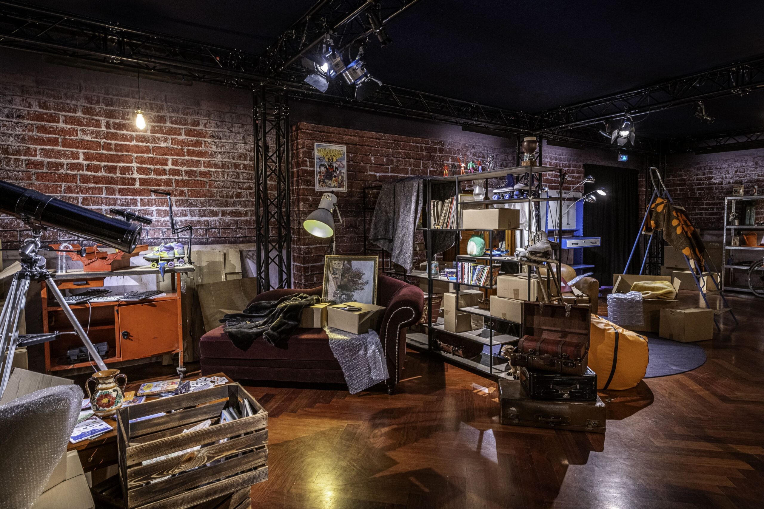 Immersive, room-scale scenography recreating a lived-in interior filled with everyday objects, books, furniture, and interactive elements, designed to place visitors in a relatable environment while addressing digital safety and awareness themes as part of the Action Innocence – Traveling educational pavilion.