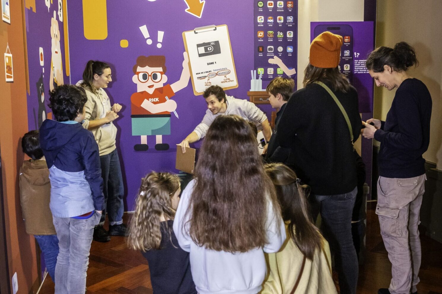 A curated still-life of everyday objects—including books, newspapers, a radio, and personal items—arranged on a table to recreate a familiar domestic environment, supporting the immersive storytelling and awareness-driven narrative of the Action Innocence traveling educational pavilion.