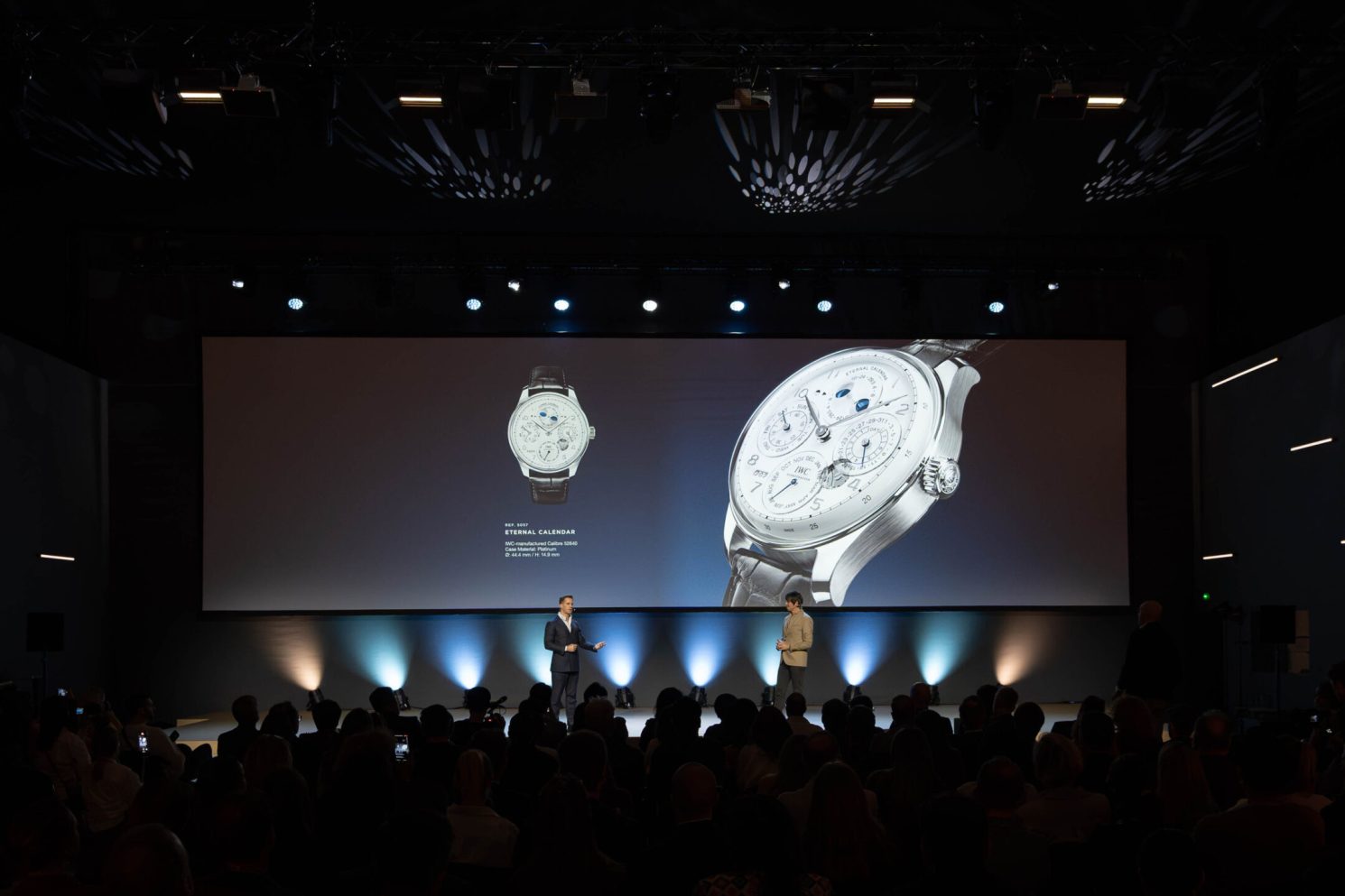 Product presentation on stage featuring a luxury watch displayed on a large screen during Watches & Wonders – Geneva International Watchmaking Exhibition.