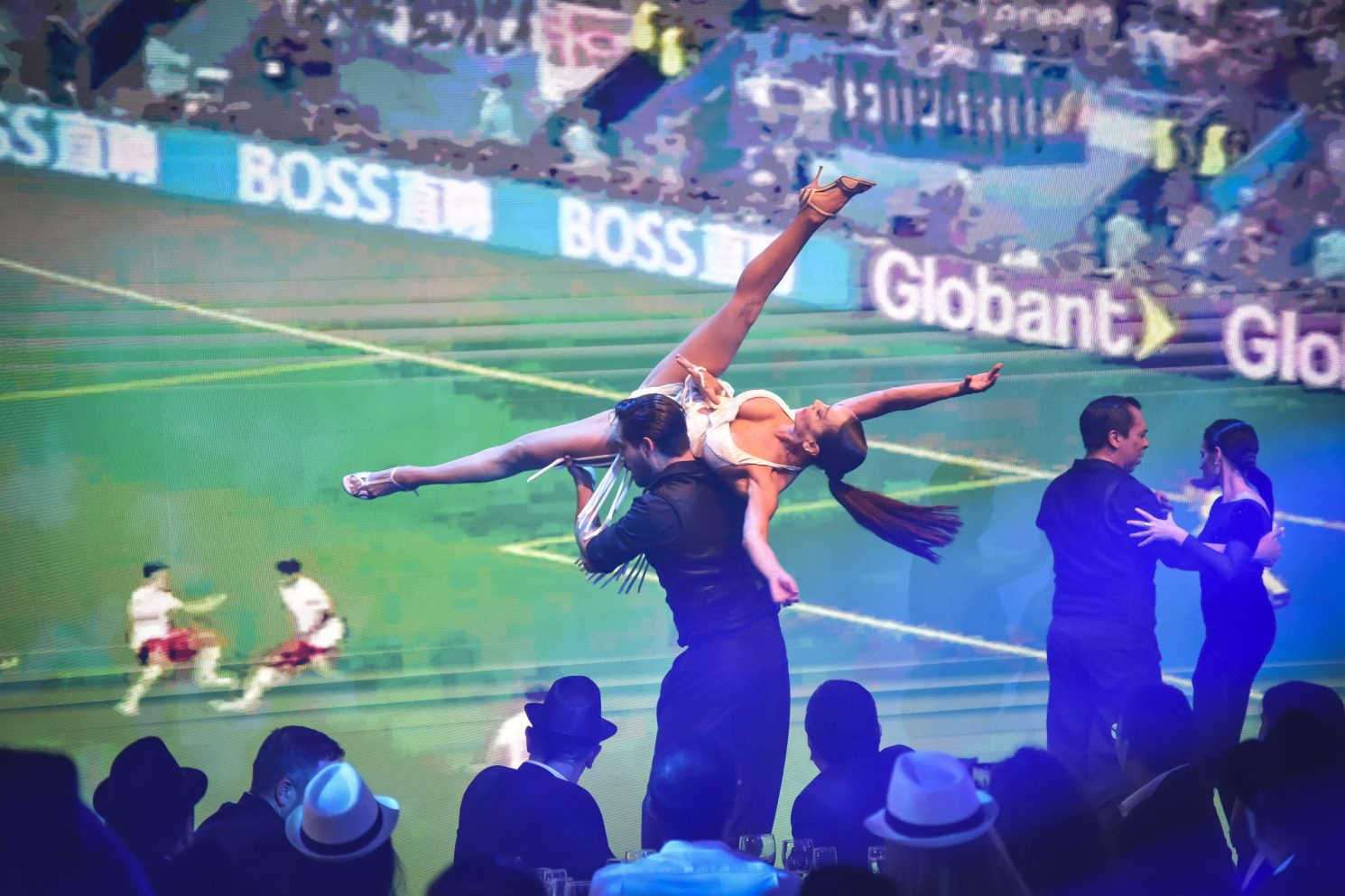 Dance performance on stage during the Conference in Buenos Aires – Immersive 360°, with performers lifted in motion in front of a large immersive sports-themed screen.