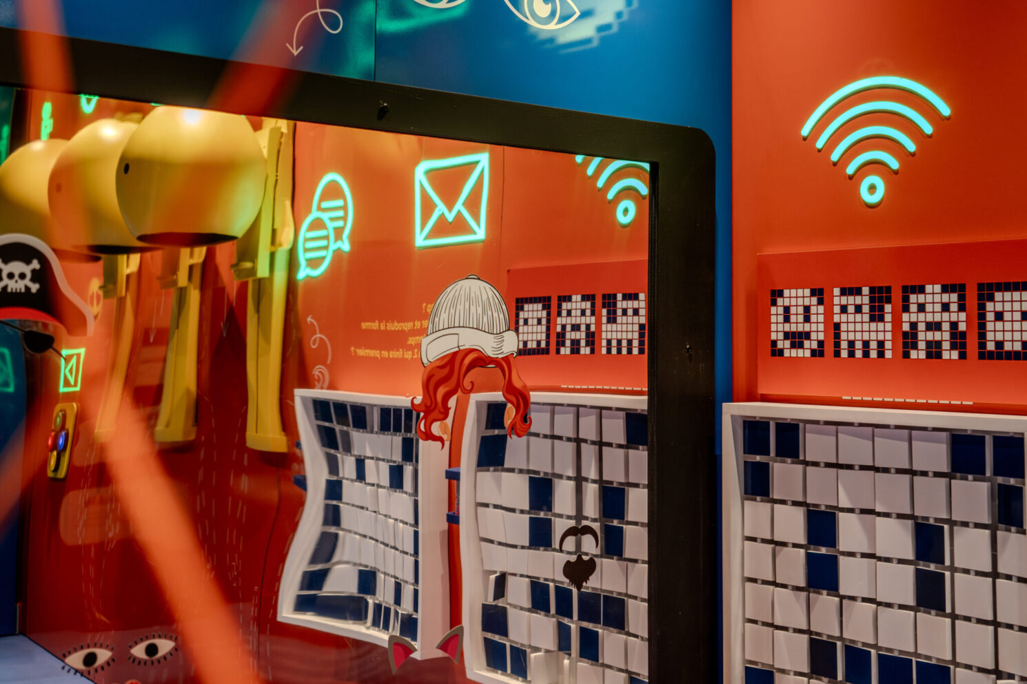 Close-up of an interactive module combining screens, pictograms, and colorful illustrations to raise awareness about digital communication and online safety.