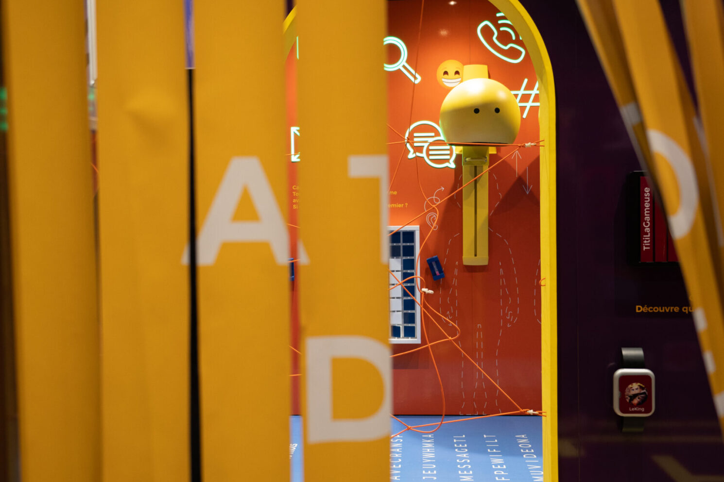 Entrance to an immersive space framed by flexible curtain elements and playful scenography, immediately drawing visitors into a visually engaging environment.
